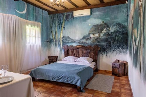 a bedroom with a bed with a painting on the wall at Resto Park Традиція in Podvorki