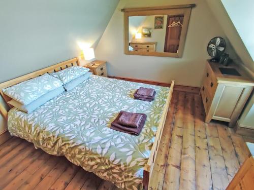 a bedroom with a large bed and a mirror at Fern Cottage in Ardentinny