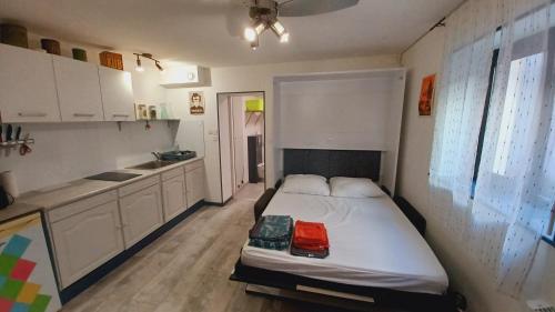 une petite chambre avec un lit et une cuisine dans l'établissement Studio Cosy tout confort Gaillac centre., à Gaillac