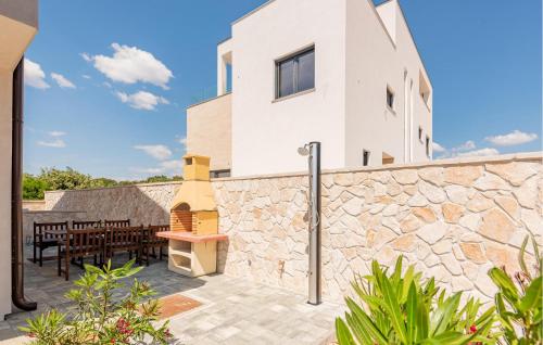 a patio with a stone wall and a building at 3 Bedroom Lovely Apartment In Mandre in Mandre