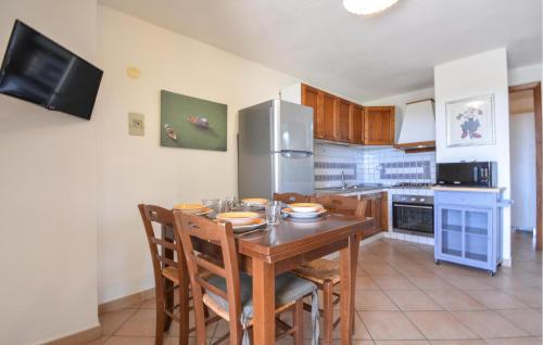 a kitchen with a table with chairs and a refrigerator at Secca in Costa Rei