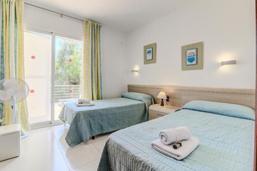 a bedroom with two beds with towels on them at Villa Vistafar by Rentallorca in Alcudia