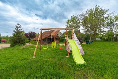 um parque infantil com um escorrega num campo em Bed and Bourgogne 