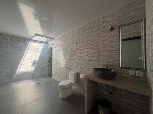 a bathroom with a sink and a toilet and a mirror at Anugerah Villa 3 in Amed