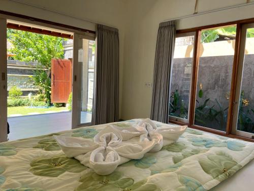 a bed with three swans pillows on top of it at Anugerah Villa 3 in Amed