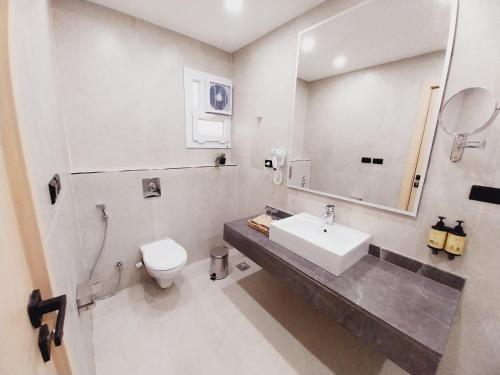 a white bathroom with a sink and a toilet at Lacasa Residence in Cairo