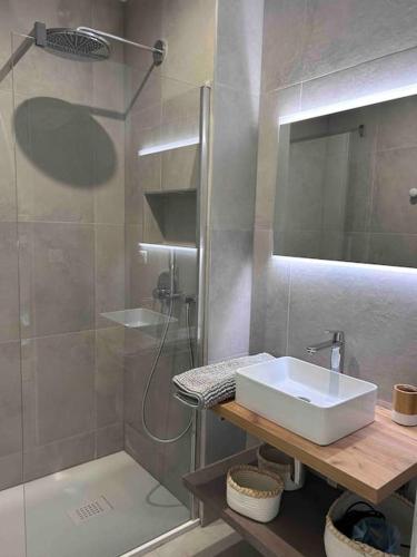 une salle de bain avec un lavabo et une douche dans l'établissement Duplex avec piscine, près de la mer, Cala Rossa, à Lecci