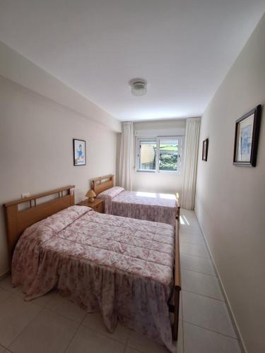 a bedroom with two beds and a window at Piso da Playa in Laxe