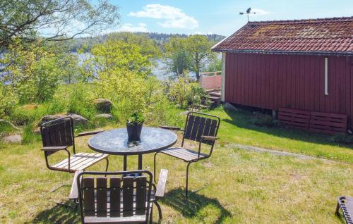 a table and four chairs in a yard with a barn at Cozy Home In Hökerum With Kitchen in Hökerum