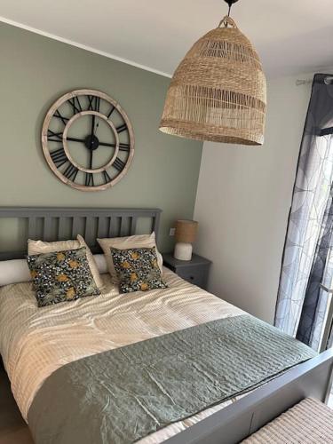 une chambre avec une grande horloge sur le mur dans l'établissement Duplex avec piscine, près de la mer, Cala Rossa, à Lecci