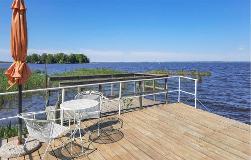 eine Terrasse mit Tisch und Stühlen und einem Sonnenschirm in der Unterkunft 3 Bedroom Lovely Home In Stora Mellösa in Stora Mellösa