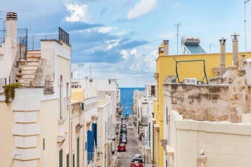 a city street with buildings and the ocean in the background at Don Nicola Tourist Location in Polignano a Mare