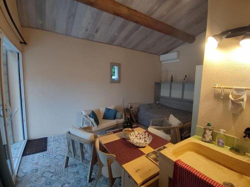 a living room with a table and a room with a couch at La cabane d'Alcée in Vacqueyras