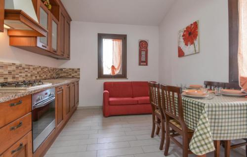 a kitchen with a table and a red couch at Secca 3 in Costa Rei