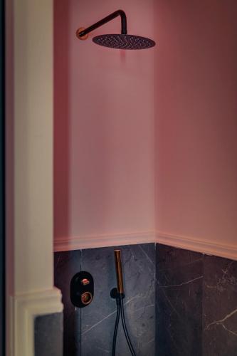 a bathroom with a shower with a shower head at Ninemian Suites Syros in Ermoupoli