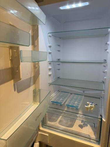 an empty refrigerator with its door open with its door at Penthouse height Flat, City View Balcony, Quiet, Free Wifi, Gym & More Minimalistic Home in Manchester