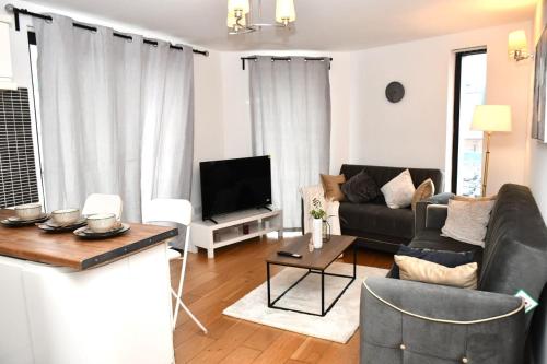 a living room with a couch and a tv at Spacious 2bedroom apartment in London city airport in London