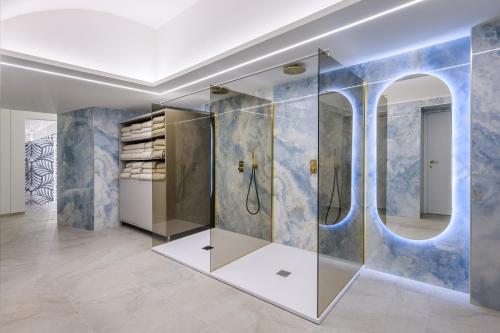 uma casa de banho com um chuveiro e um espelho. em Grand Hotel Villa Serbelloni - A Legendary Hotel em Bellagio