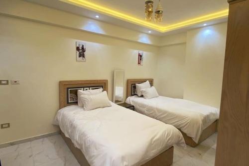 two beds in a room with white walls at Luxury 3 bedroom Apartment with a great Seaview* in Abū Qīr