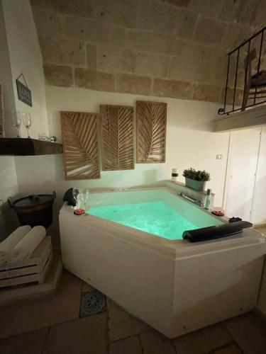 y baño con bañera de agua azul. en B&B Casa Fiore, en Polignano a Mare