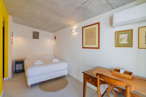 een slaapkamer met een bed en een houten bureau bij CASA UMI - Magnifique appartement avec accès privé à la mer et grande terrasse in Marseille