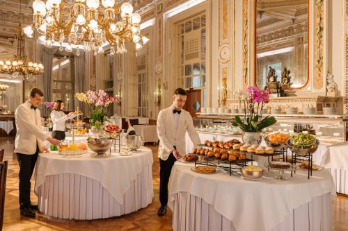 a group of men standing in front of tables with food at Grand Hotel Villa Serbelloni - A Legendary Hotel in Bellagio