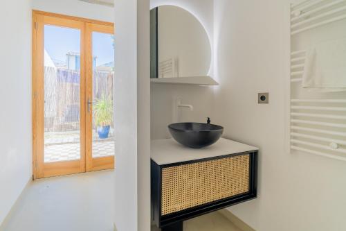 La salle de bains est pourvue d'un lavabo et d'une fenêtre. dans l'établissement CASA UMI - Magnifique appartement avec accès privé à la mer et grande terrasse, à Marseille
