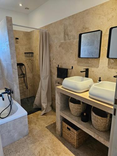 une salle de bain avec une baignoire, un lavabo et une douche dans l'établissement Maison en pierres, à Porto-Vecchio