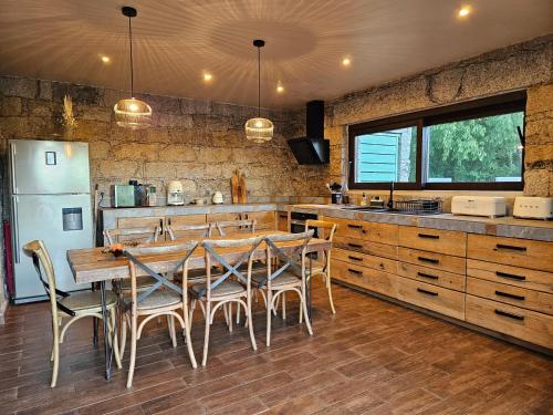 une cuisine avec une table, des chaises et un réfrigérateur dans l'établissement Maison en pierres, à Porto-Vecchio