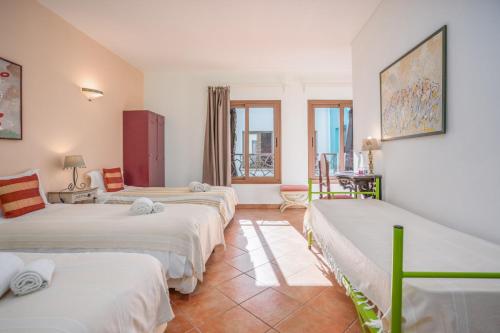 a room with three beds in it with a table at Alvor Ar de Mar in Alvor