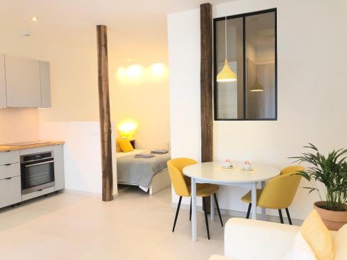 eine Küche und ein Wohnzimmer mit einem Tisch und Stühlen in der Unterkunft Auterive-Évasions-Échapée-parking gratuit, hypercentre, gare in Auterive