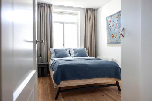 a bedroom with a bed with blue sheets and a window at Gorgeous And Stylish Place For Two In Hip West! in Amsterdam