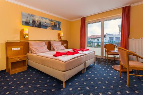 a hotel room with a bed and a window at Hotel & Restaurant Hanse Kogge in Ostseebad Koserow