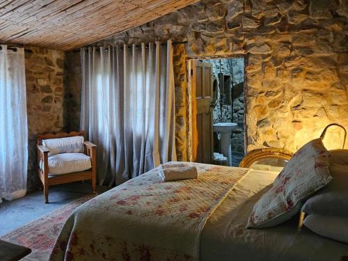 1 dormitorio con cama y pared de piedra en The Riverdeck Accommodation and Backpackers en Knysna
