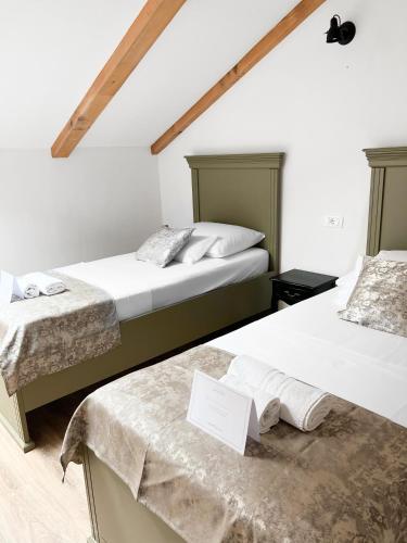 two beds in a room with white walls at Centrum Luxury Rooms in Šibenik