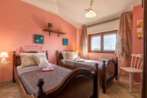 a bedroom with two beds and a window at Casa Clara in Uri in the Nuraghe of Santa Cadrina a short distance from the beaches in Uri