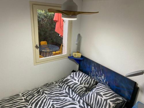 - un canapé à motifs zébrés dans une chambre avec fenêtre dans l'établissement Joli f2 bord de mer, à Leucate