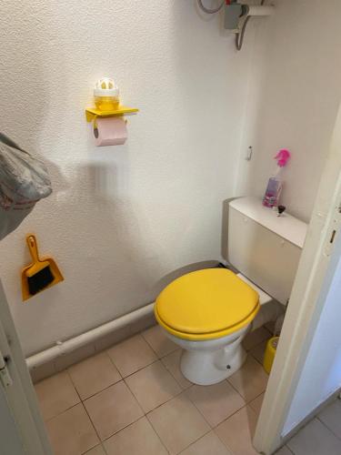 une salle de bain avec des toilettes jaunes avec un couvercle jaune dans l'établissement Joli f2 bord de mer, à Leucate