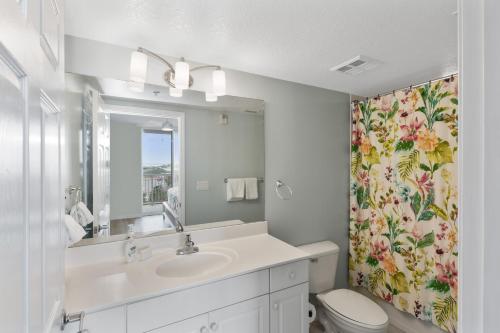 a bathroom with a sink and a toilet and a mirror at Destin West Sandpiper Bld 501 Bay side Condo in Fort Walton Beach