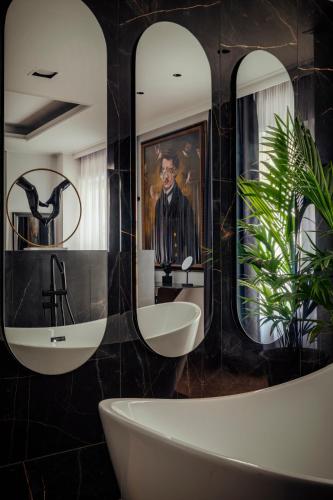 a bathroom with two sinks and two mirrors at Ninemian Suites Syros in Ermoupoli