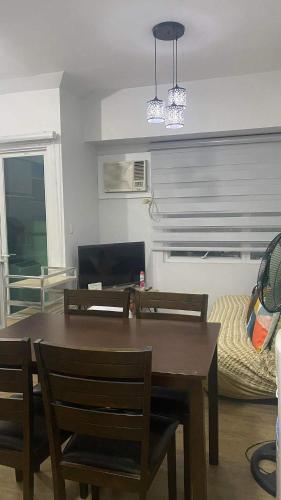 a dining room with a table and chairs and a couch at Staycation One bedroom in Manila