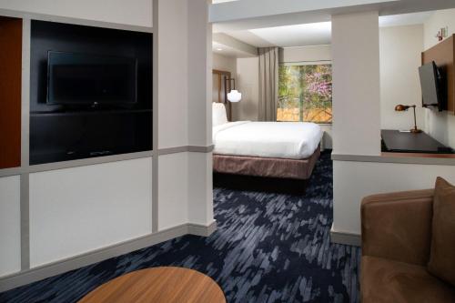 Fairfield Inn & Suites Greensboro Wendover في جرينسبورو: غرفة فندقية بسرير وتلفزيون بشاشة مسطحة