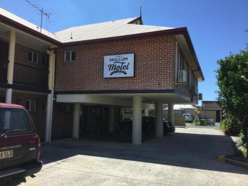 a brick building with a sign for a monday market at The Mullum Motel in Mullumbimby
