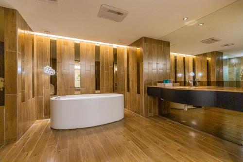 a bathroom with a white tub and wooden walls at 里萊行旅 - Lilai Motel in Taoyuan