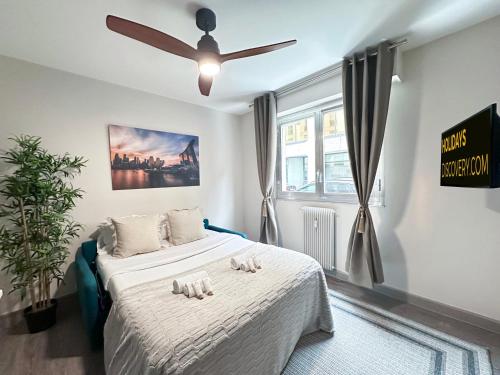 Schlafzimmer mit einem Bett und einem Deckenventilator in der Unterkunft 1601 - Charming studio in Paris Olympic Games 2024 in Paris