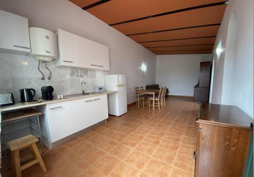 a kitchen with white cabinets and a table and chairs at Vila Dias in Mértola