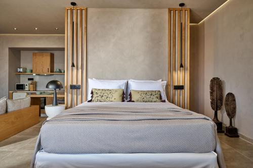 a bedroom with a large bed with pillows at Nami Suites - Alenia in Chania Town