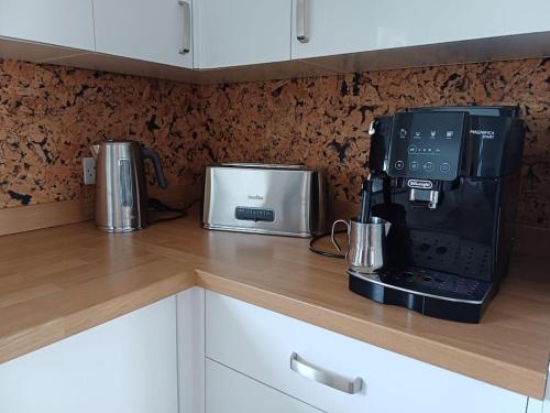 a kitchen counter with a coffee maker and a microwave at Arundel Central Apartment with parking in Arundel
