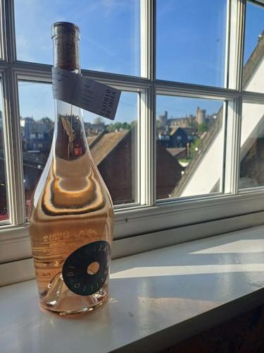 a bottle of alcohol sitting on a window sill at Arundel Central Apartment with parking in Arundel