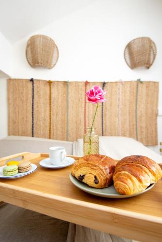 une table avec une assiette de pain et un vase avec une rose dans l'établissement Havre de paix entre Paris et CDG, au Blanc-Mesnil